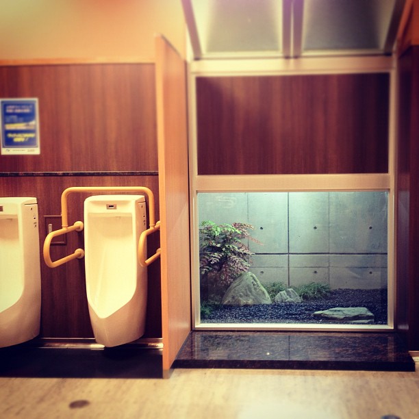 Jardin intérieur japonisant dans les toilettes pour hommes d’une station service