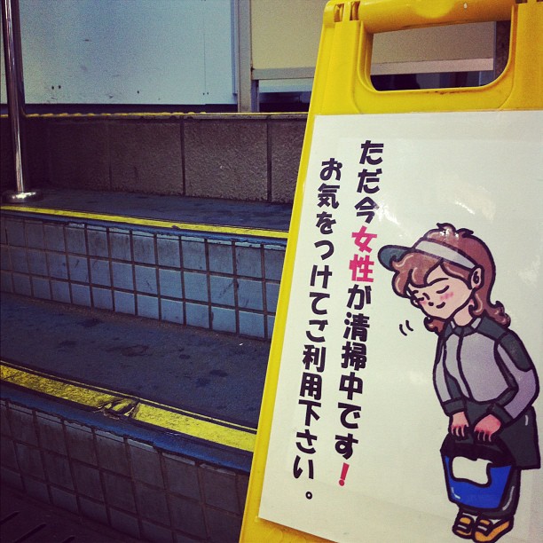 Attention, une femme nettoie les toilettes (homme) !