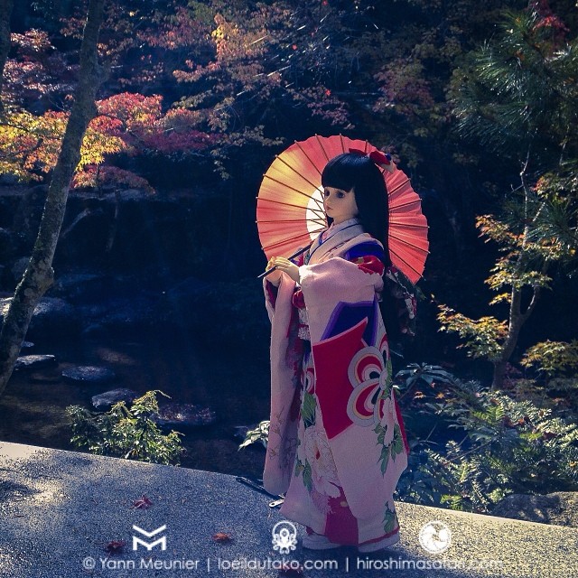 Une jolie poupée japonaise en kimono prends la pose sous les momiji de Miyajima.
